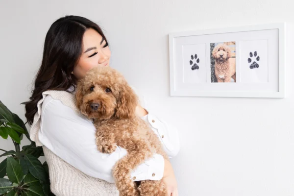 Woman hugging dog and looking at Pet Paw Prints Picture Frame